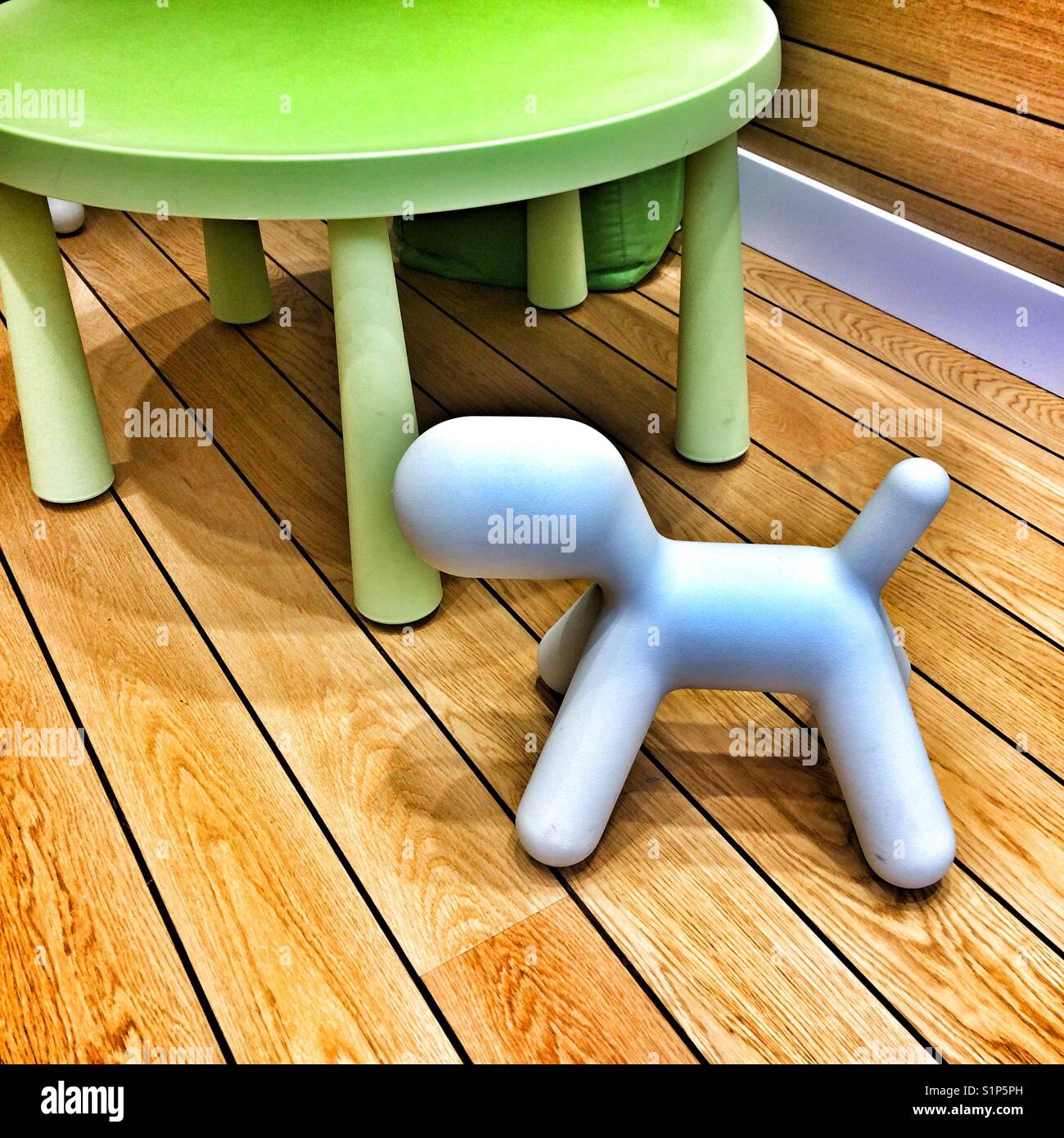 Toy dog and table on wooden floor Stock Photo