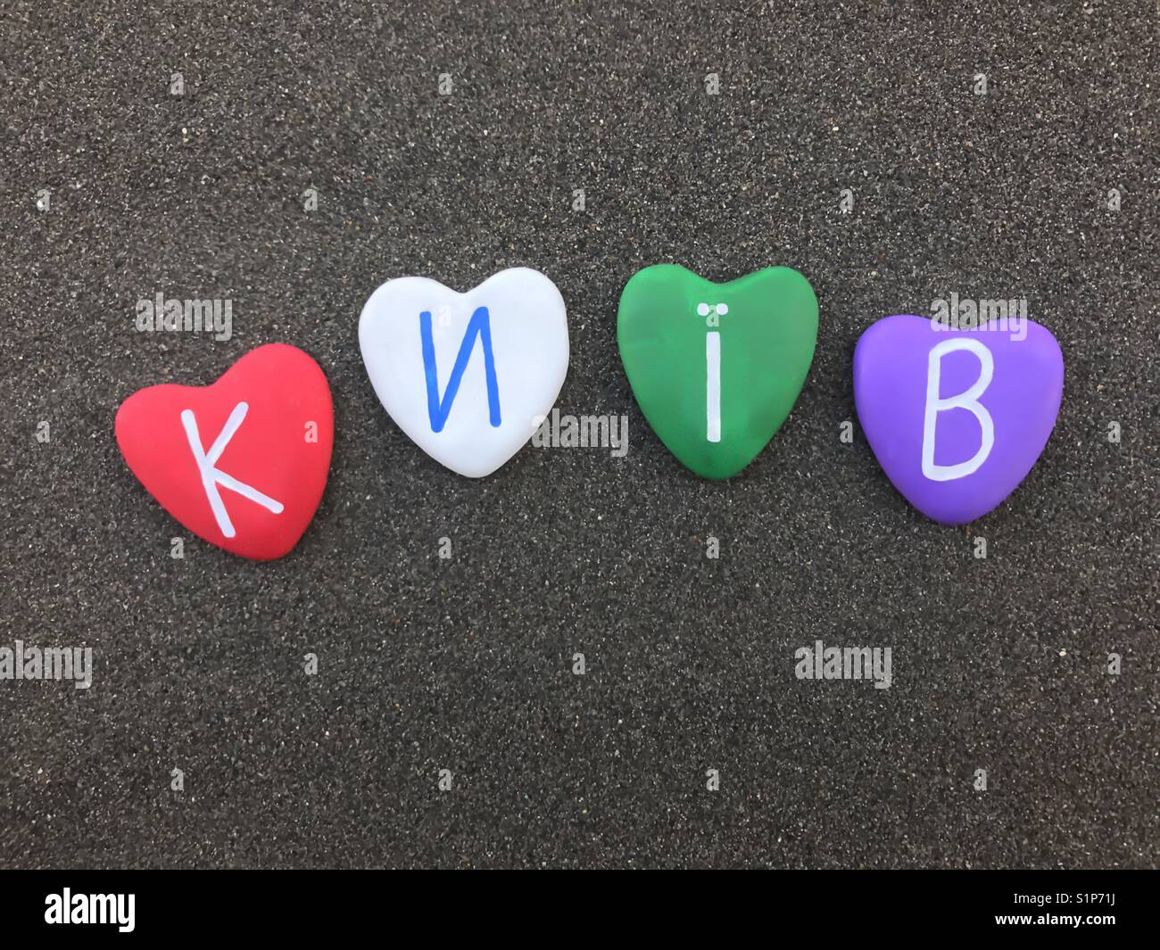 Київ,Україна, souvenir of Kiev with four colored heart stones over black volcanic sand - Smartphone Captured Stock Image