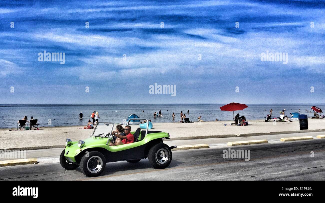 Green dune buggy driving by a beach. - Smartphone Captured Stock Image