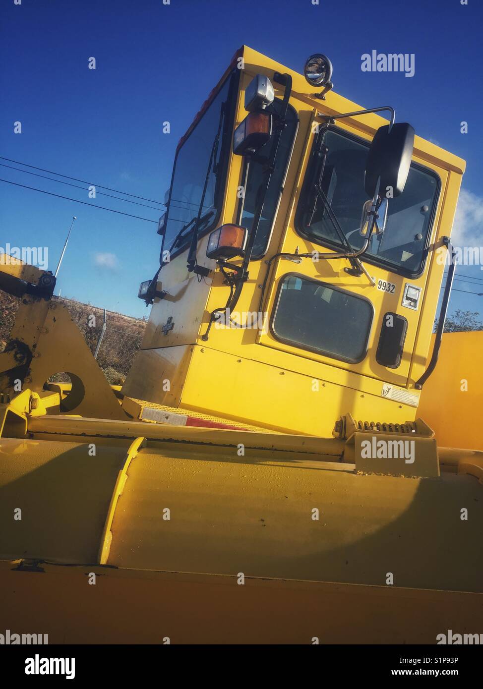 A large yellow piece of heavy machinery at an airport Stock Photo