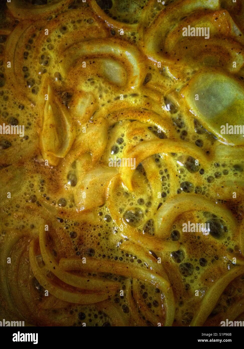 Onions sautéing in coconut oil and spicy curry. - Smartphone Captured Stock Image