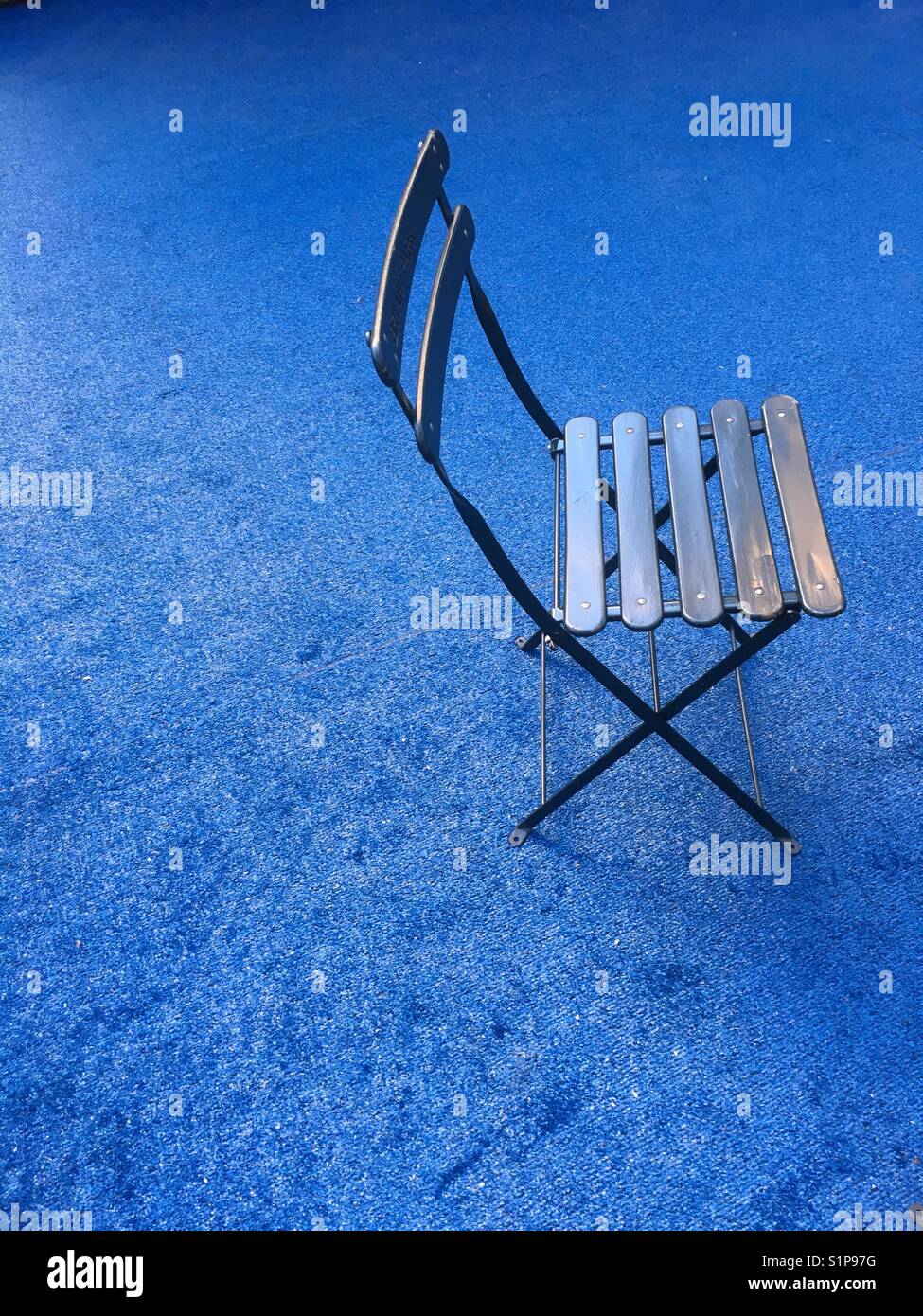 Single chair on a blue background - Smartphone Captured Stock Image