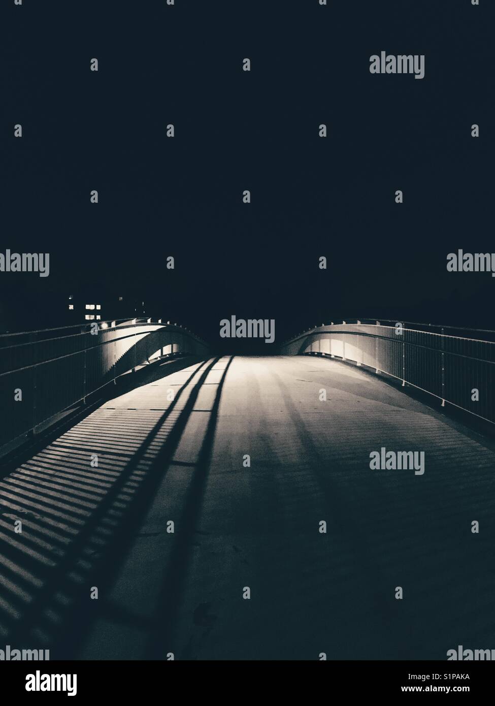 A dark pedestrian bridge in the city at night - Smartphone Captured Stock Image