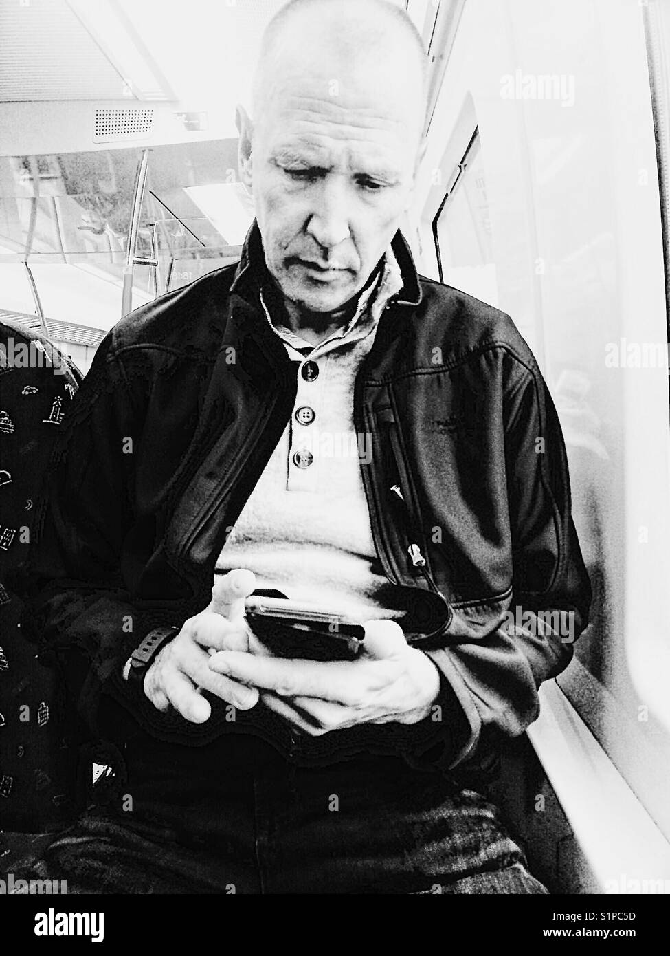 Middle aged Scandinavian man using smartphone on the train, Sweden - Smartphone Captured Stock Image