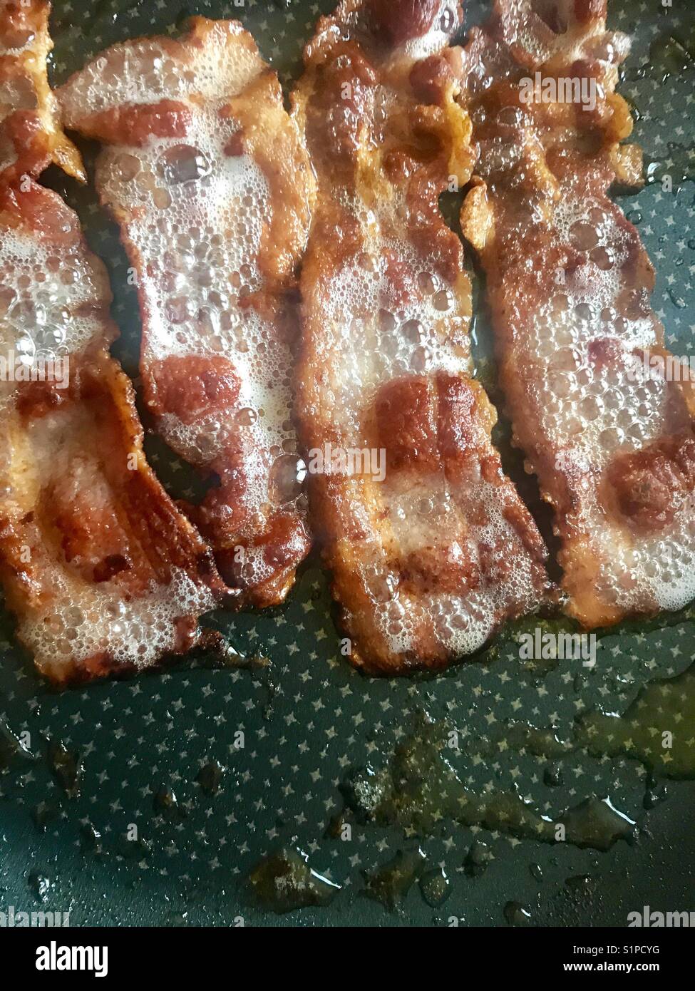 Frying bacon in a pan Stock Photo Alamy