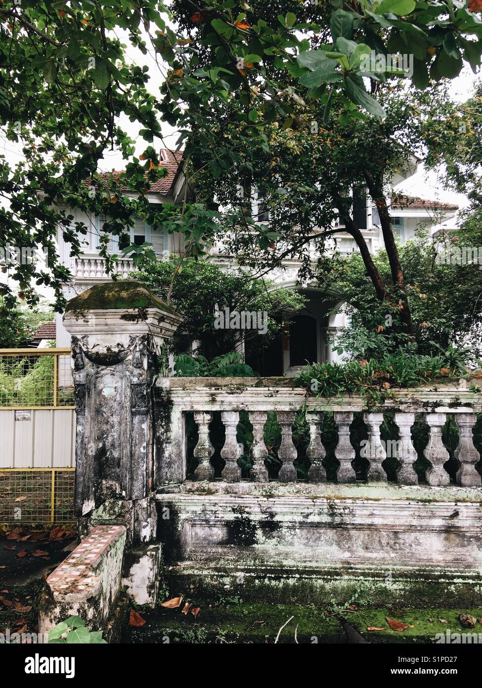 old house in a colonial style surrounded by unleashed greenery Stock Photo