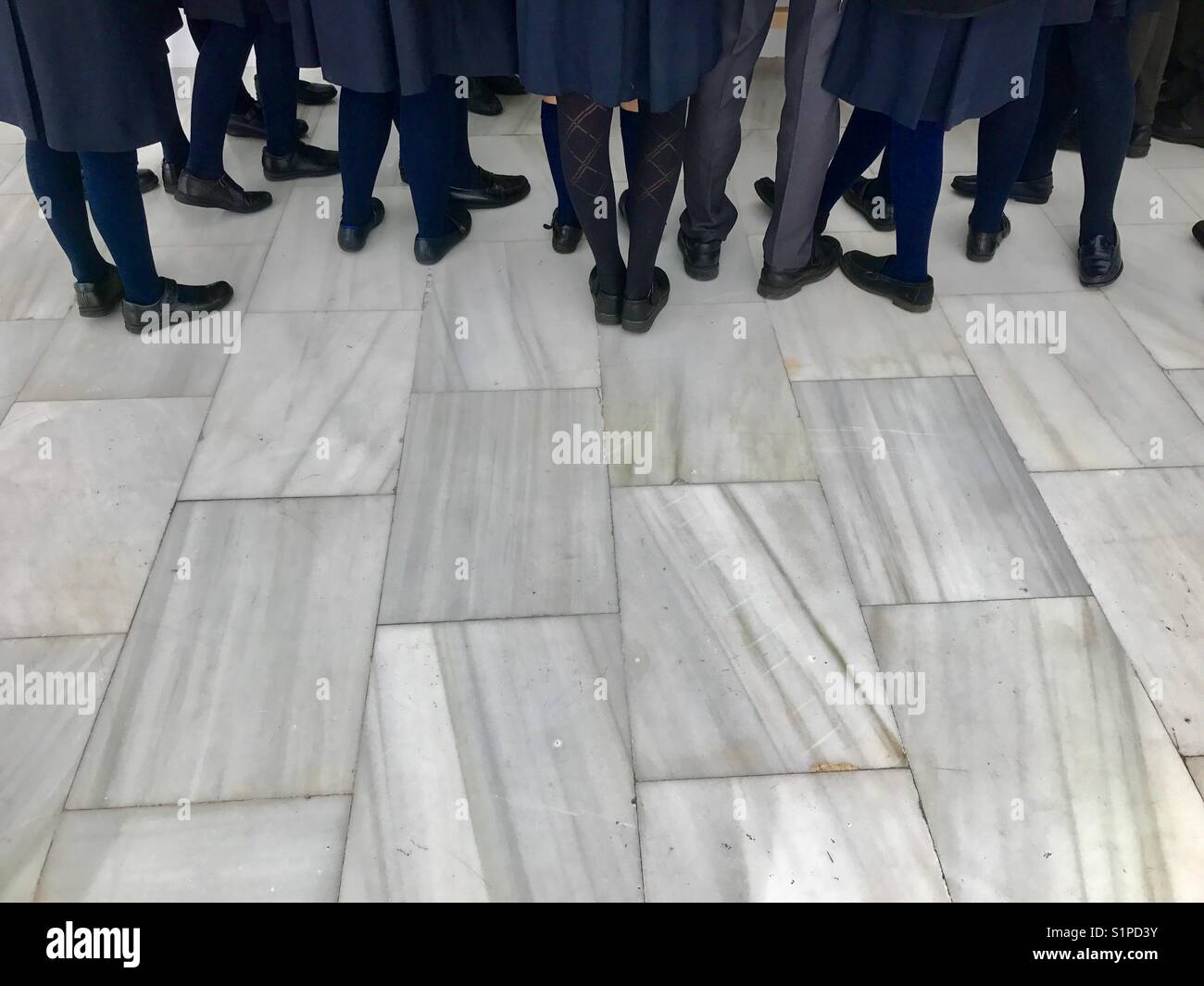 Legs of students on marble floor. - Smartphone Captured Stock Image
