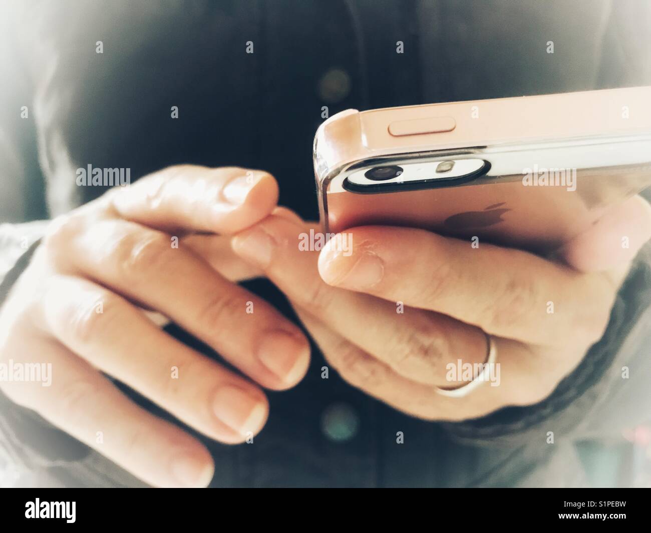 Wireless technology. Woman using an iPhone. Mid section, close-up of phone in hands. - Smartphone Captured Stock Image