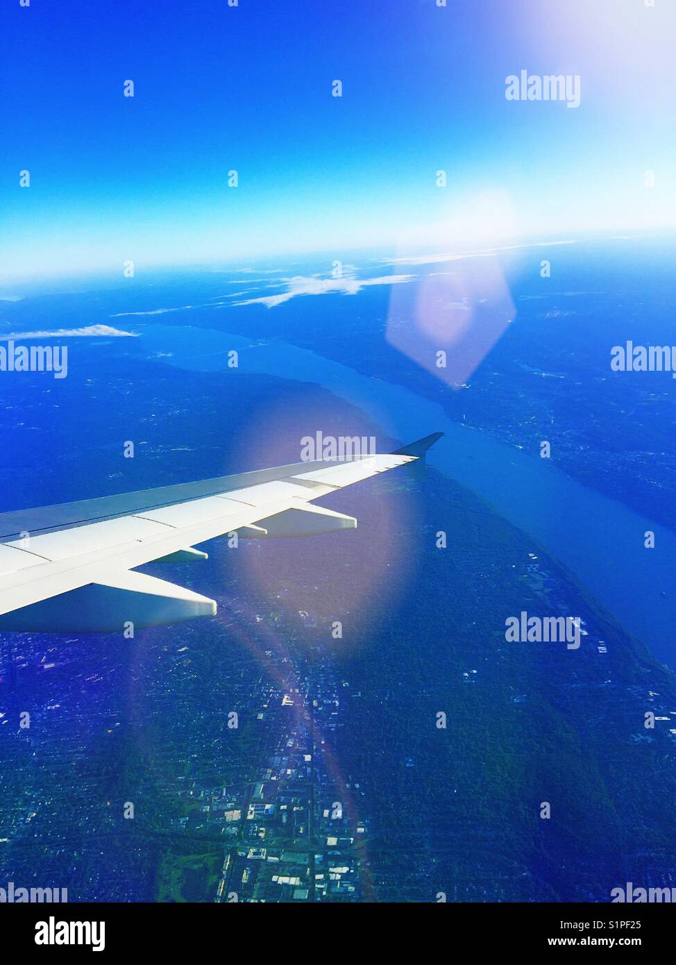 Wing of  passenger jet aircraft in flight taken from passenger seat window, USA - Smartphone Captured Stock Image