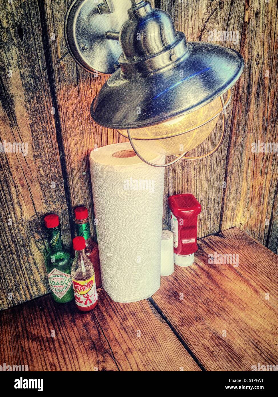 Condiments and roll of paper towels on the table of a casual seafood restaurant, South Carolina, USA Stock Photo
