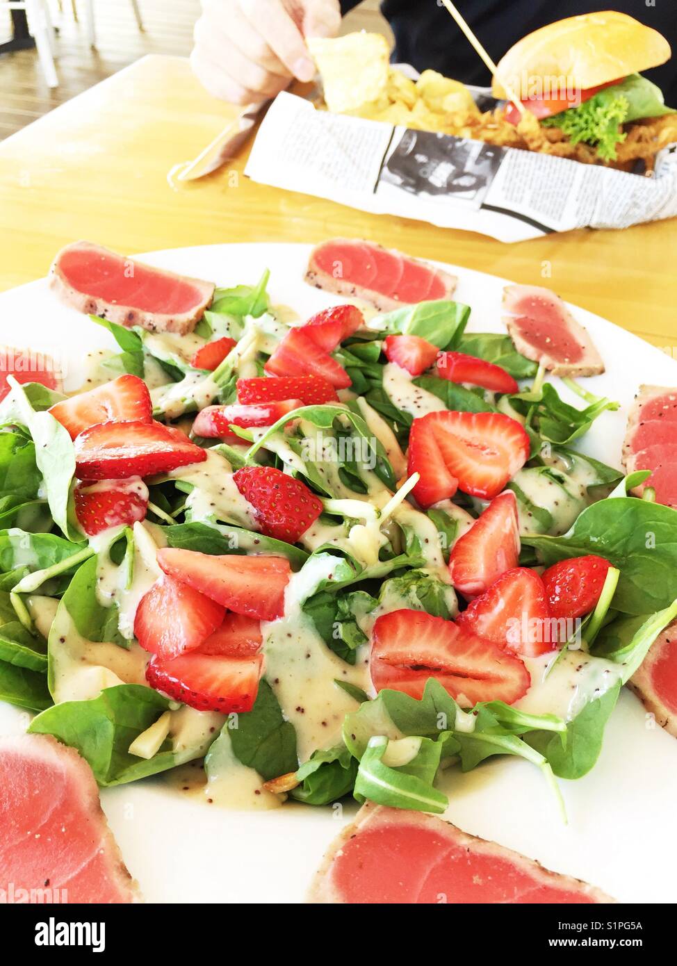 Main course salad of seared tuna, strawberries and spinach greens, seafood restaurant, USA - Smartphone Captured Stock Image