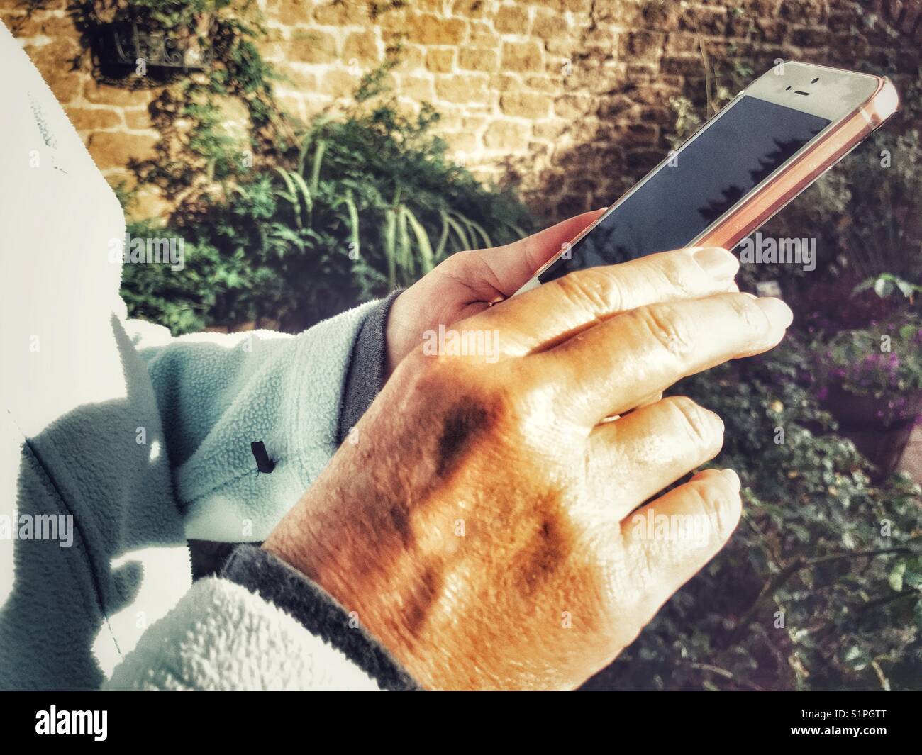 Woman using iPhone, outdoors in winter - Smartphone Captured Stock Image