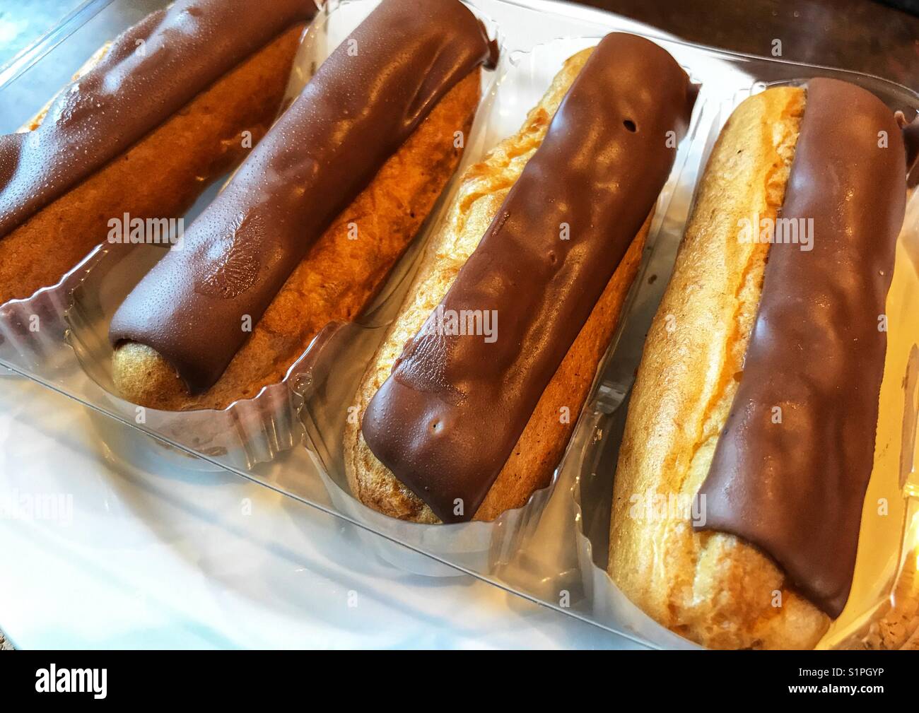 Four chocolate eclairs in the plastic packaging Stock Photo Alamy