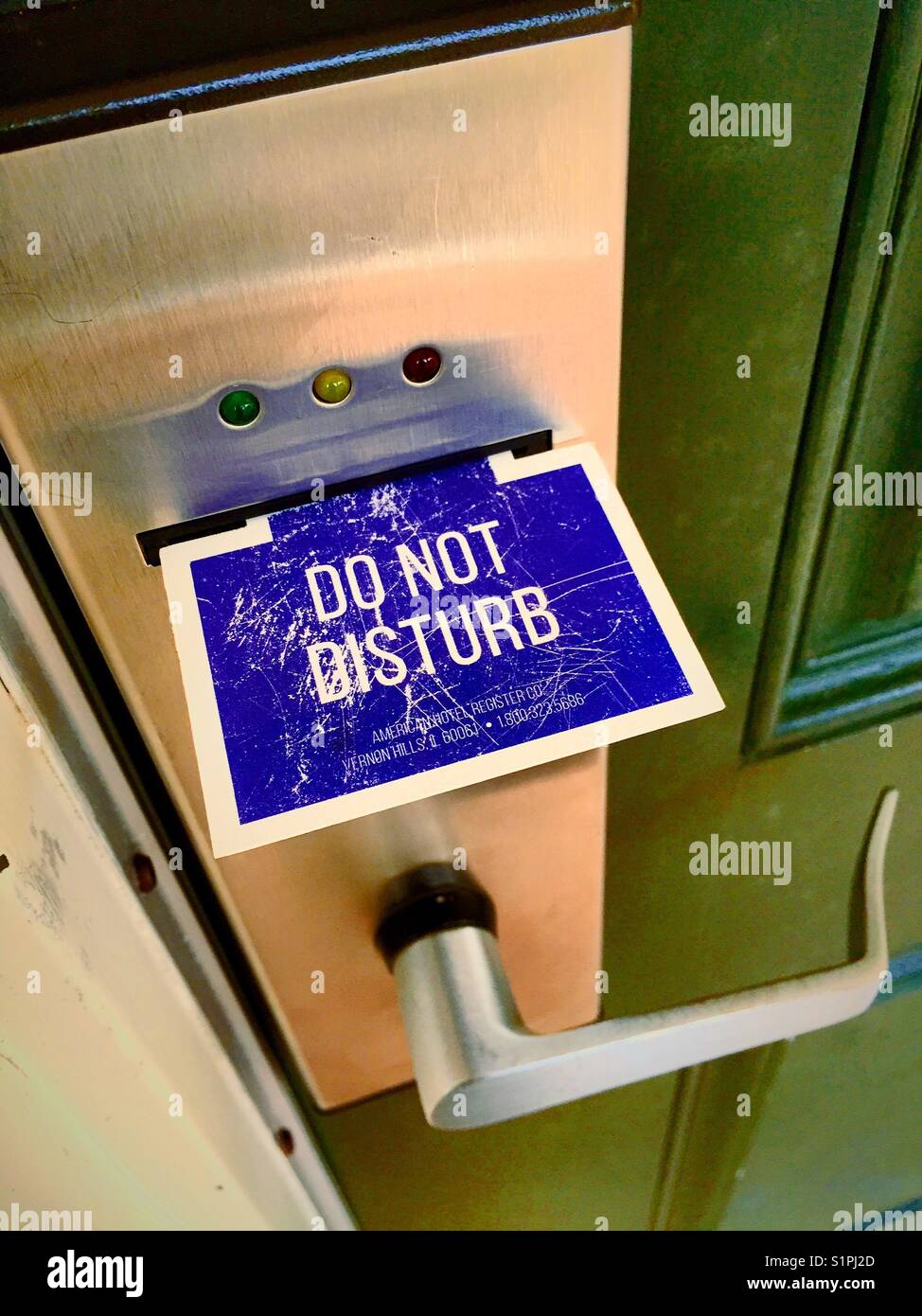 Hotel room door with do not disturb tab in key card lock and handle, USA - Smartphone Captured Stock Image