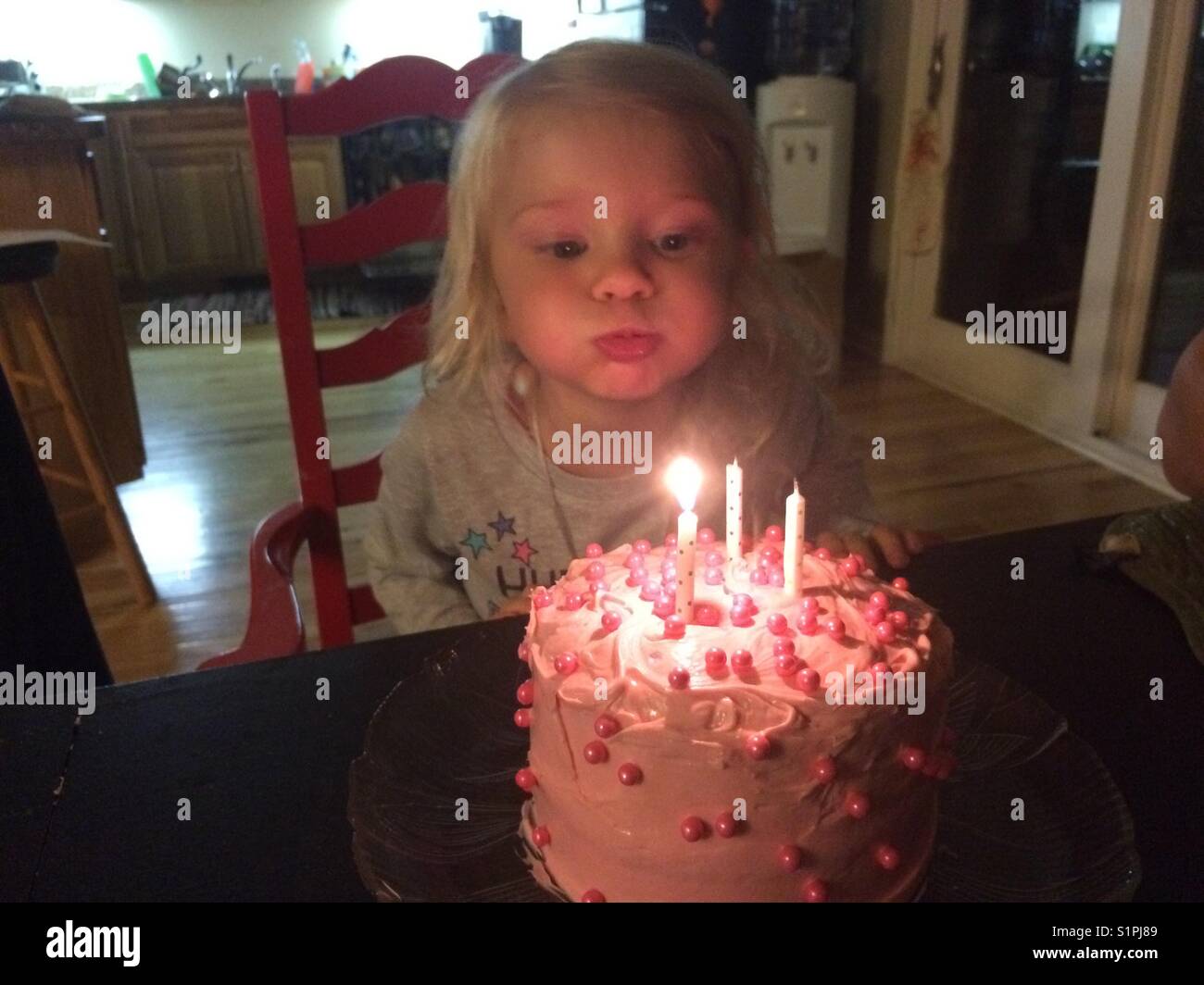 Girl blowing out Birthday candles Stock Photo Alamy