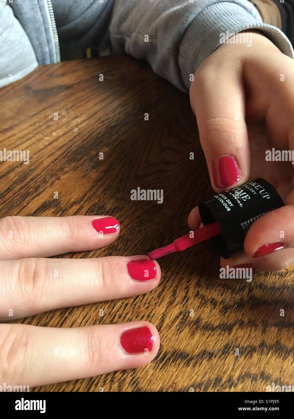 Teenager applying pink nail varnish - Smartphone Captured Stock Image