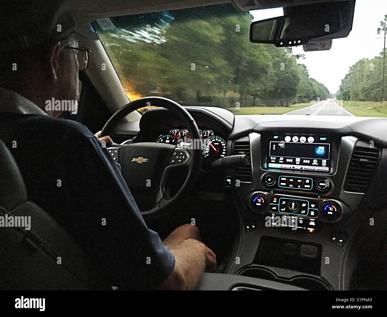 SENIOR MAN DRIVING. New Chevy Tahoe, USA - Smartphone Captured Stock Image