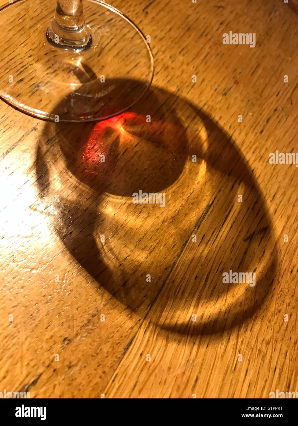 Reflection of glass if red wine on wooden bar table - Smartphone Captured Stock Image