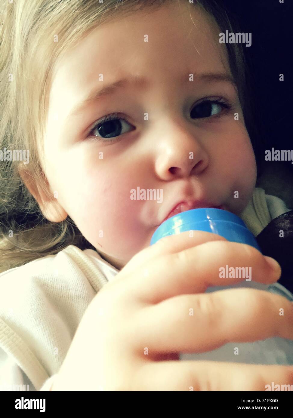 Baby girl drinking from baby bottle hires stock photography and images