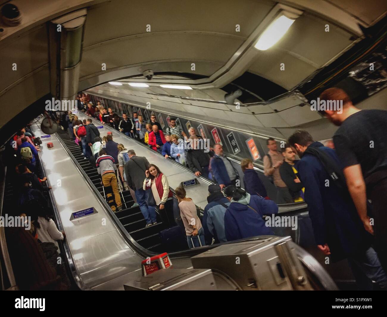 People travel on the escalators at Victoria tube station in London, England - Smartphone Captured Stock Image