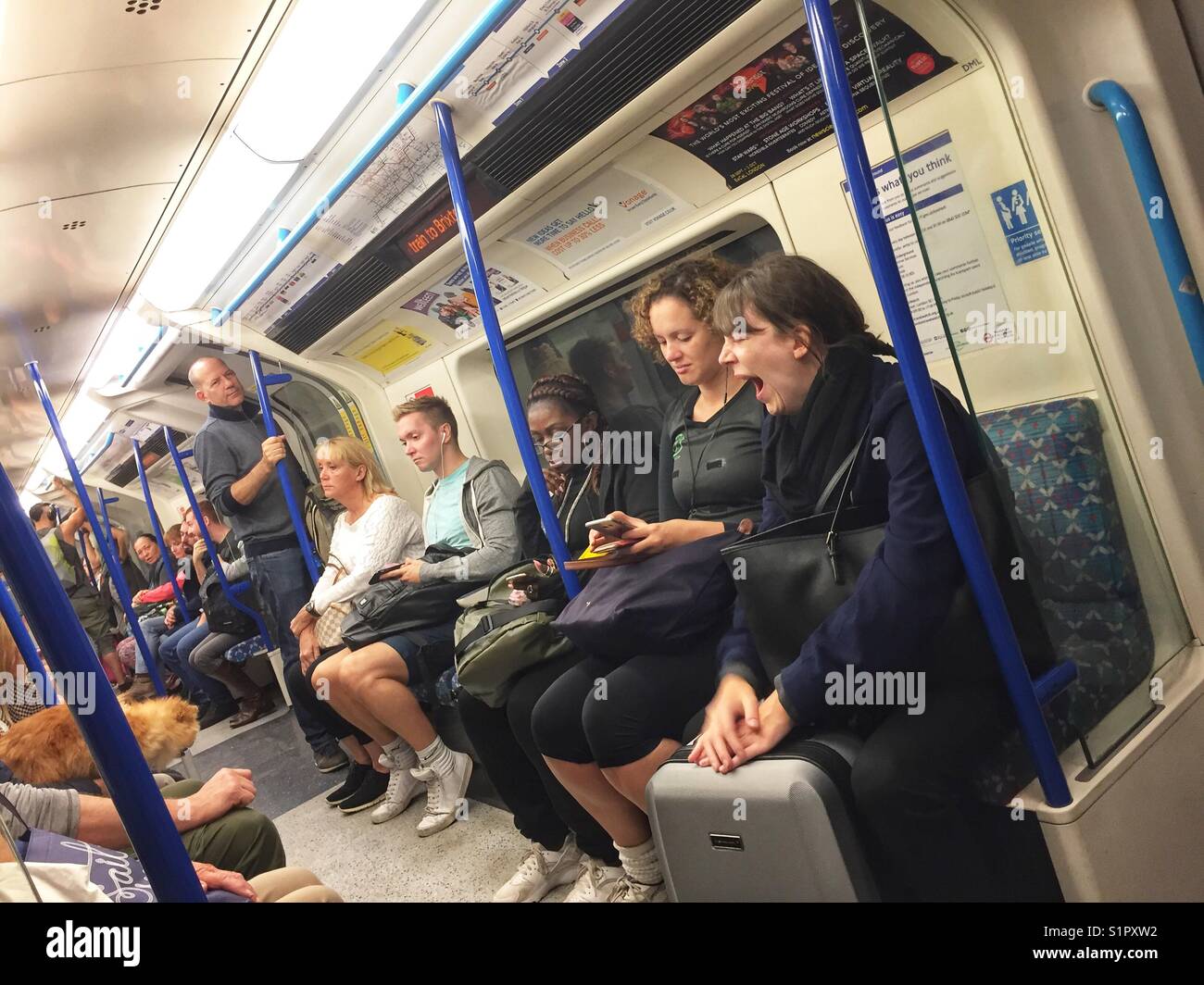 People commute on a London Underground tube train, England - Smartphone Captured Stock Image