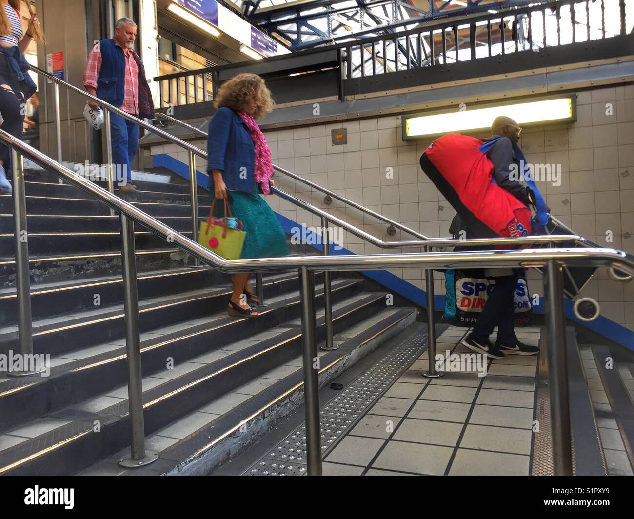 Commuters walk down the stairs to Victoria underground station in London - Smartphone Captured Stock Image