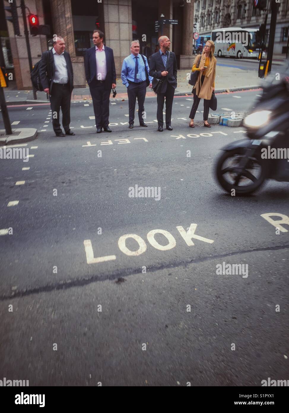 Pedestrians wait to cross a busy road in central London, England - Smartphone Captured Stock Image