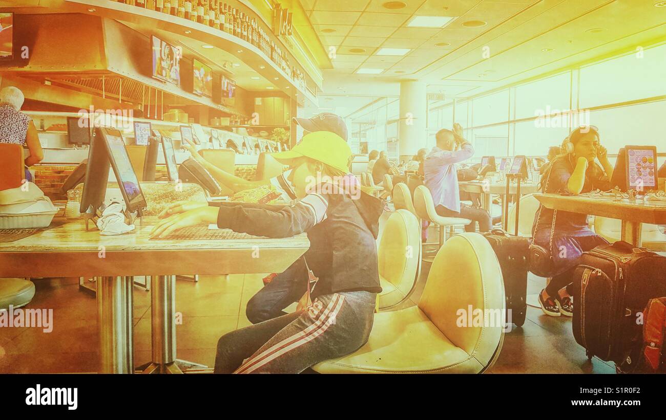 Passengers on tablets at Toronto Pearson International Airport, Toronto, Ontario, Canada - Smartphone Captured Stock Image