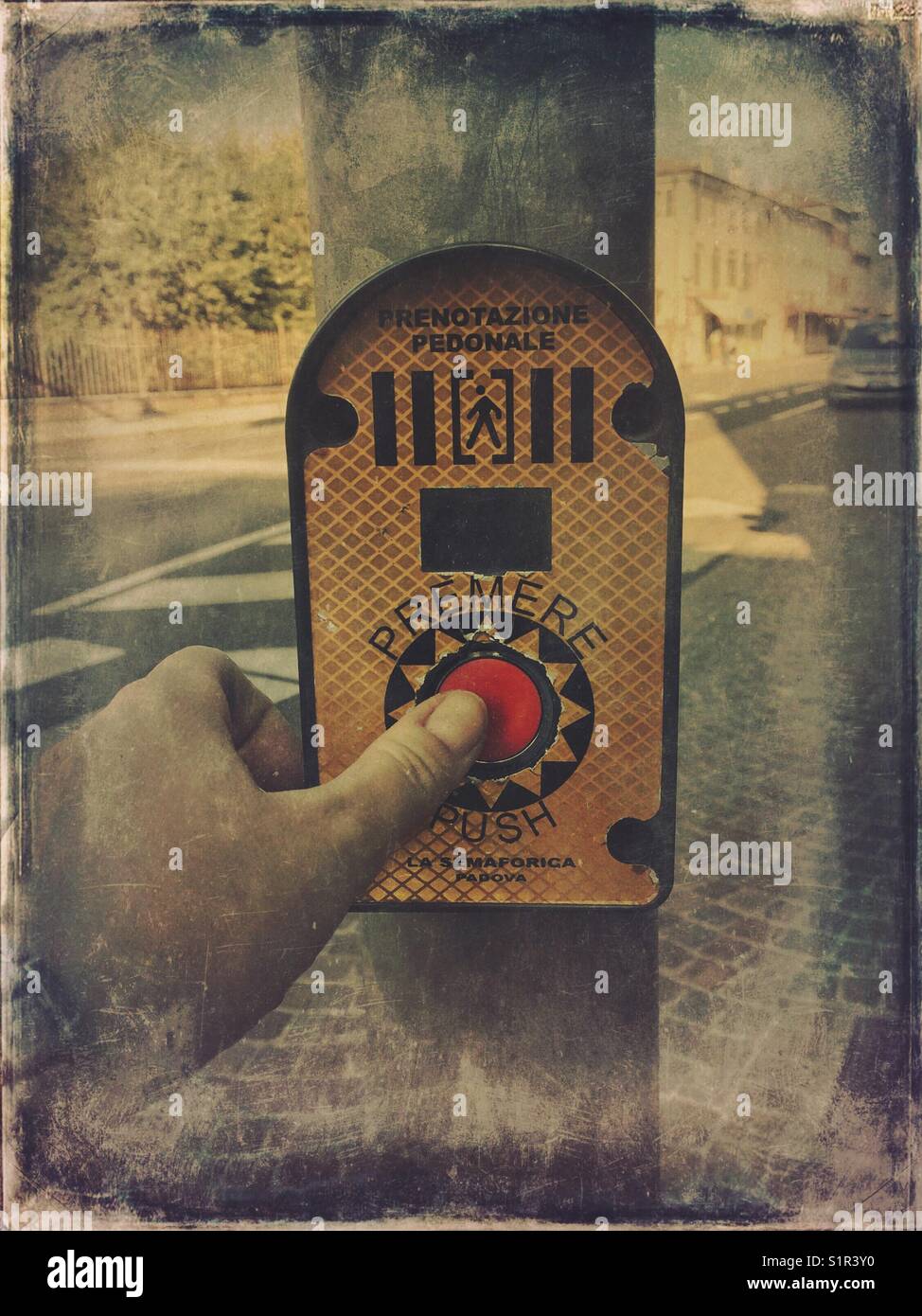 Pedestrian pressing push button on pedestrian crossing - Smartphone Captured Stock Image