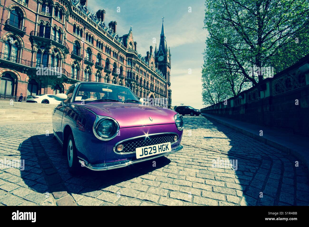 A classic purple car outside the Saint Pancras Renaissance hotel in King’s Cross London showing the UK’s upper class element and lifestyle. - Smartphone Captured Stock Image