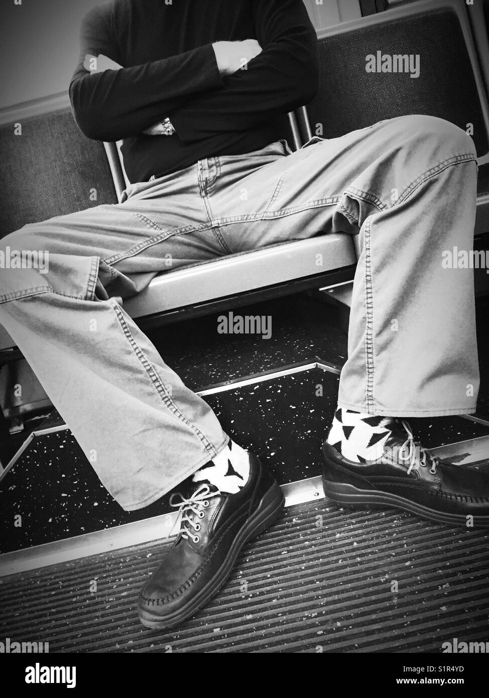 Man hogging seats on New York City bus by man spreading, USA - Smartphone Captured Stock Image