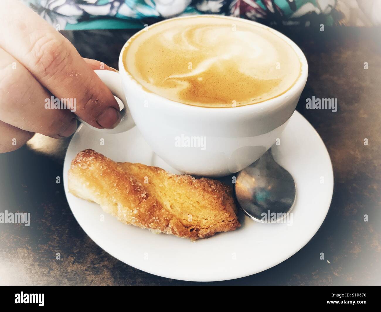 Cappuccino coffee,sweet biscuit, high angle view with woman’s hand Stock Photo