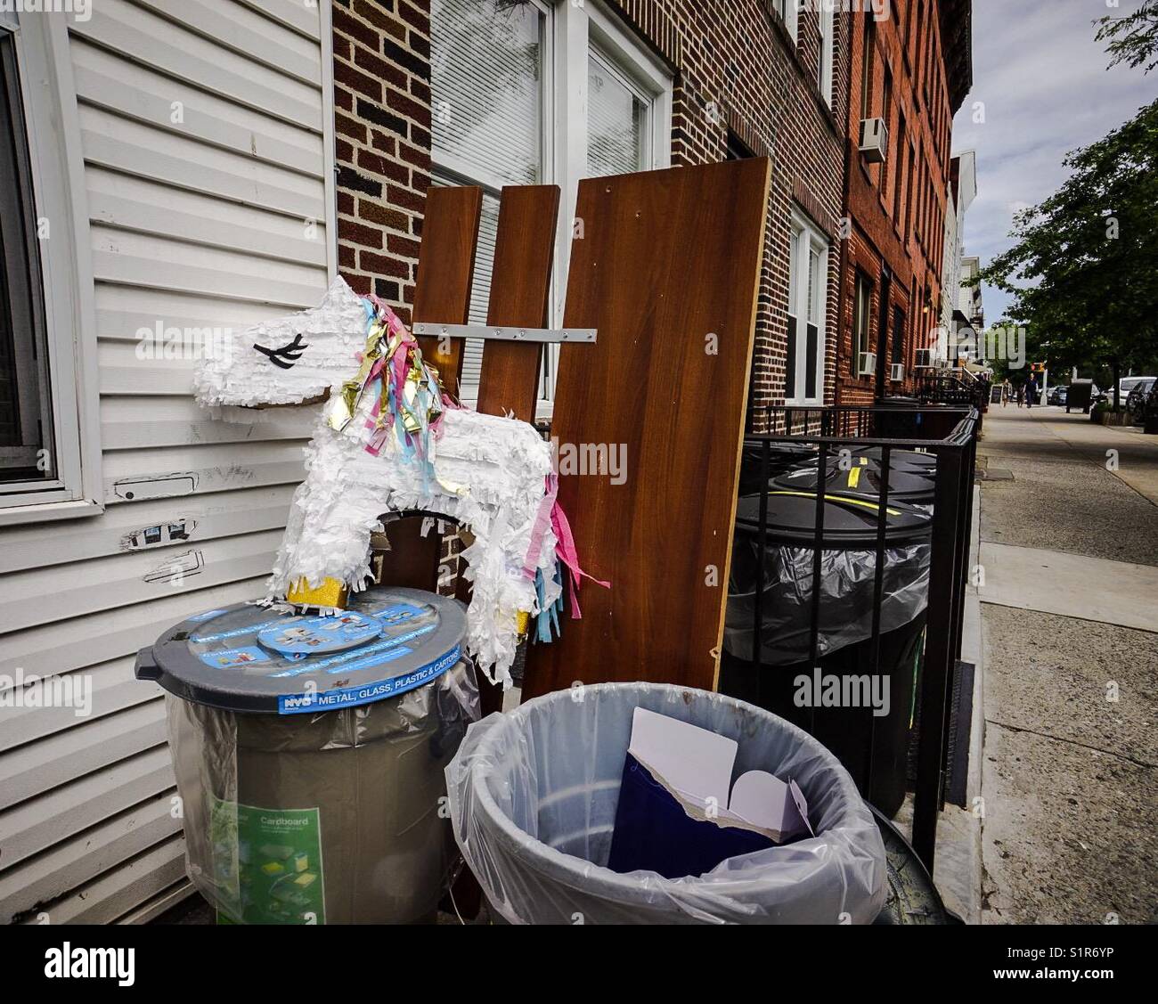 Unicorn piñata in the trash bin outside a Brooklyn house - Smartphone Captured Stock Image