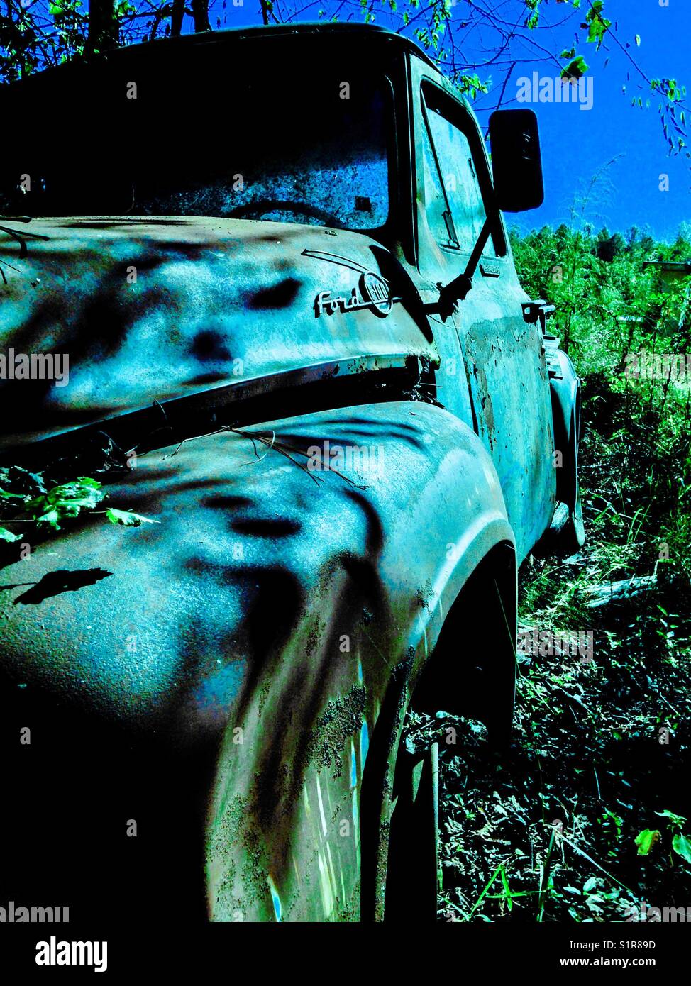 Blue tinted photo of abandoned vintage F100 Ford pickup Stock Photo