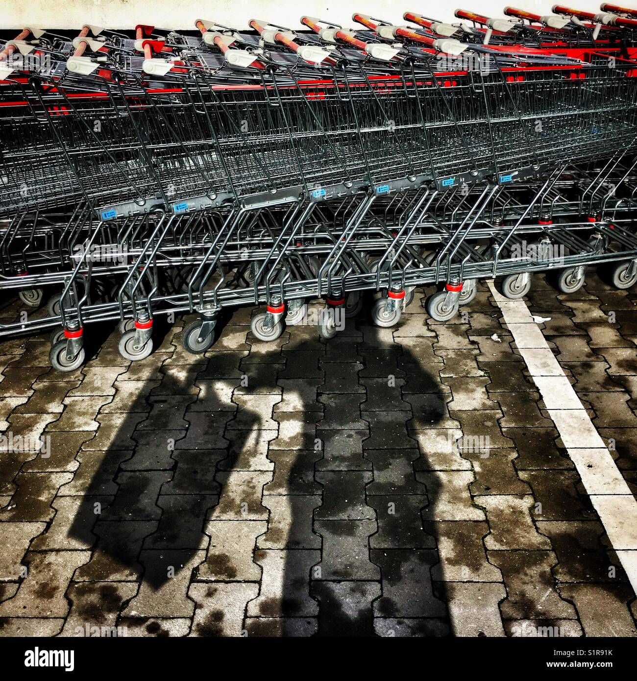 Silhouette of customer with bag and supermarket carts - Smartphone Captured Stock Image