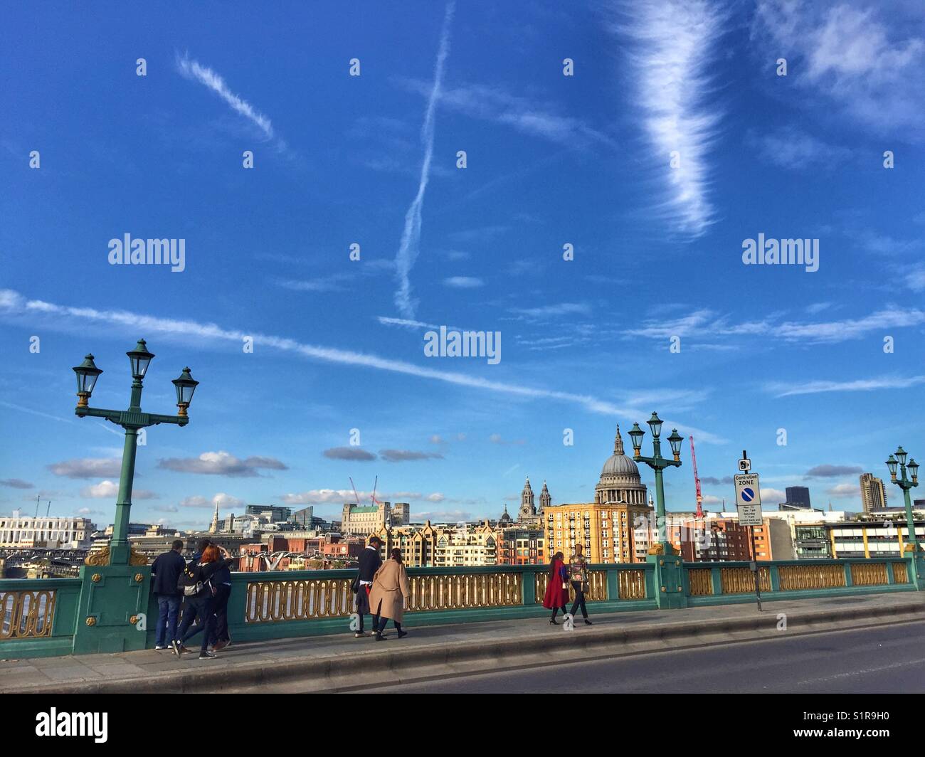 People walk across Southwark Bridge in London, England. Photo taken in October 2017 - Smartphone Captured Stock Image
