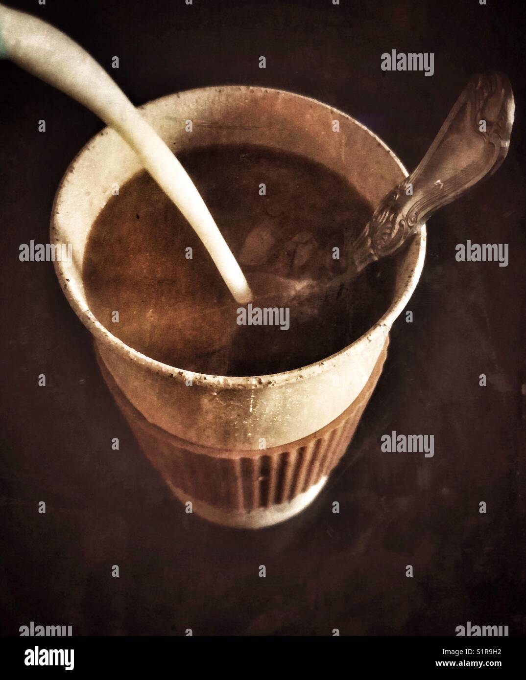 Pouring milk into coffee in reusable takeout cup - Smartphone Captured Stock Image