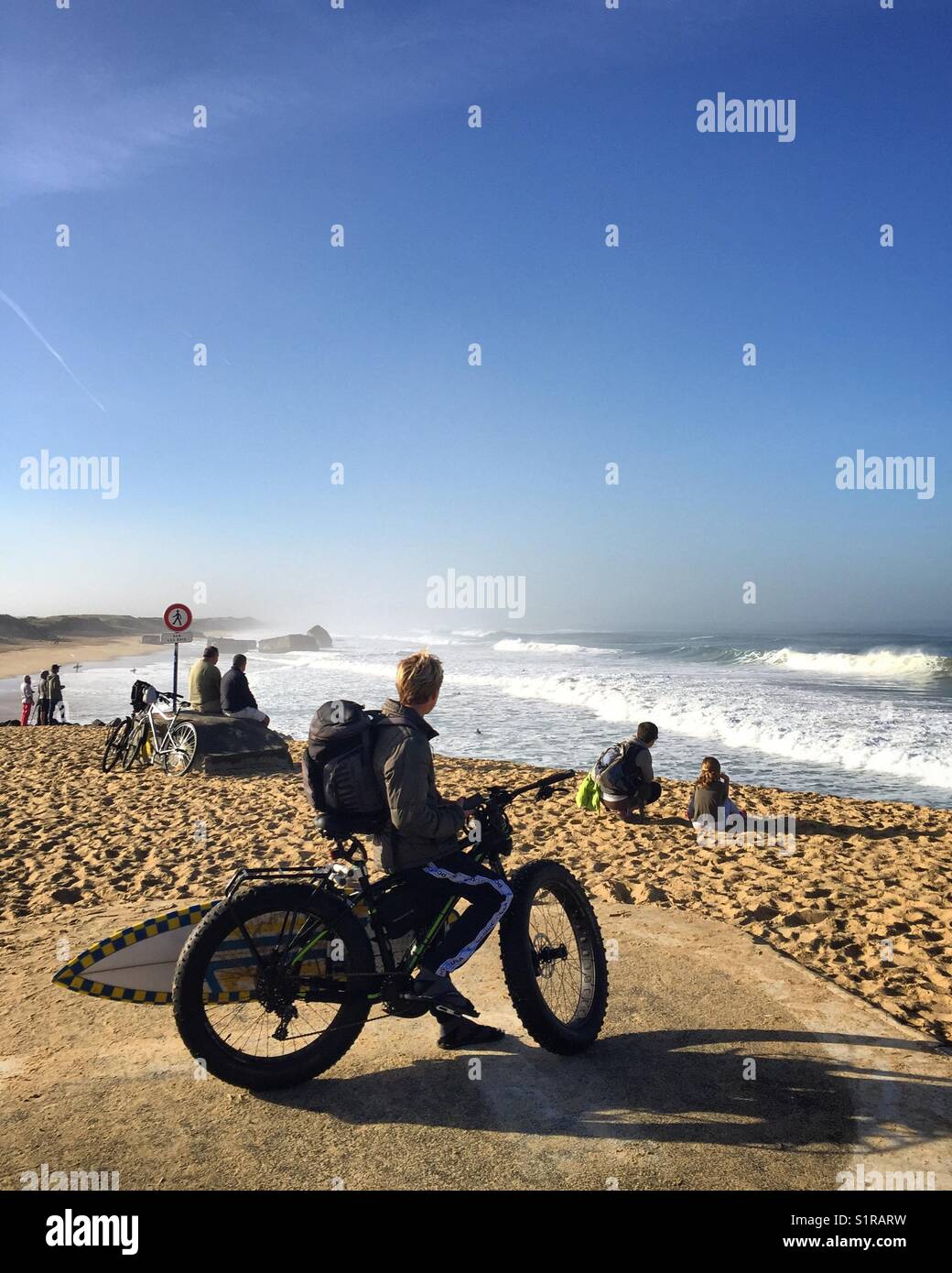 Young surfer watching the waves on a Fatbike in South-West France. Stock Photo