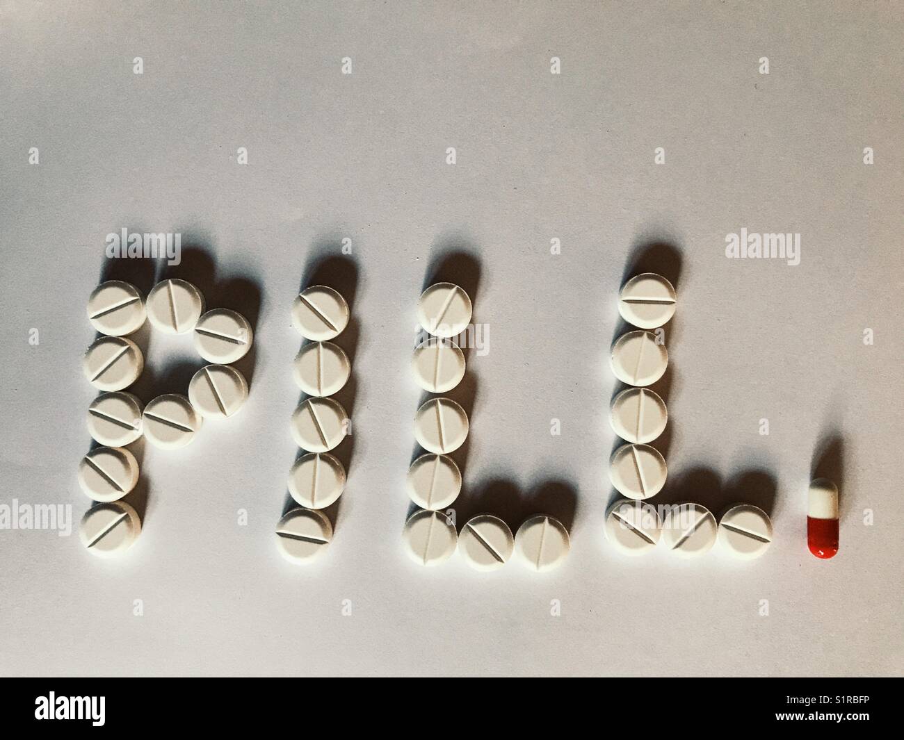 Healthcare and medicine. Pills spelling the word Pill - Smartphone Captured Stock Image