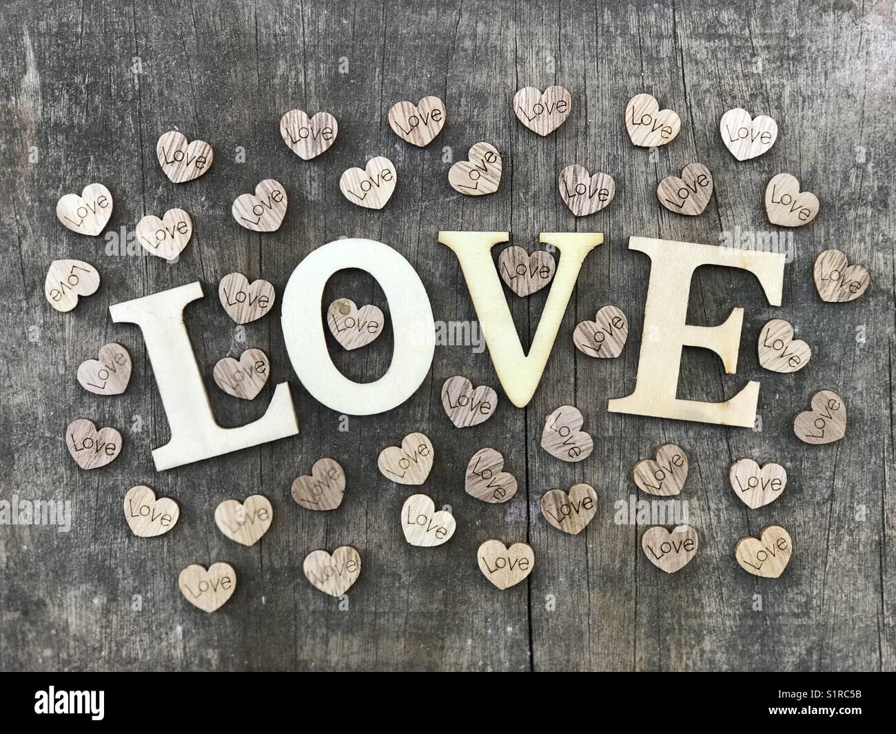 Love text with wooden letters and many little wooden hearts Stock Photo