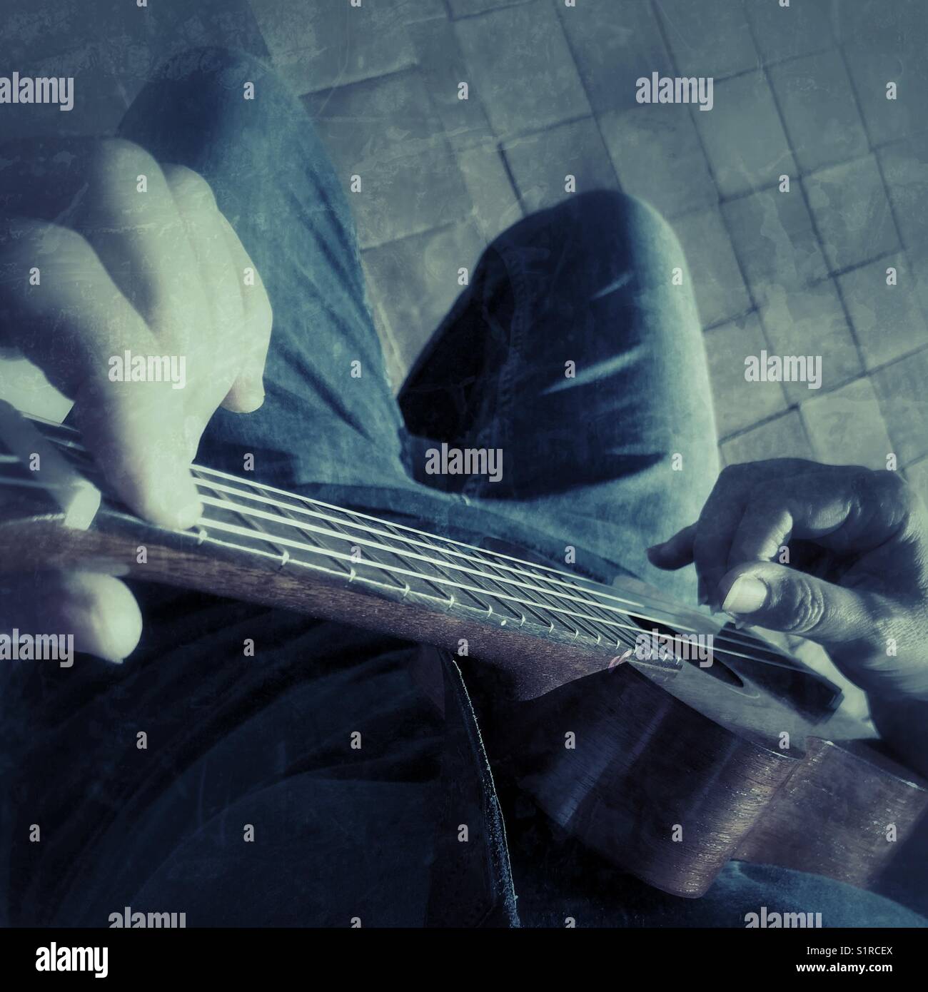 Woman playing a ukulele, high angle view - Smartphone Captured Stock Image