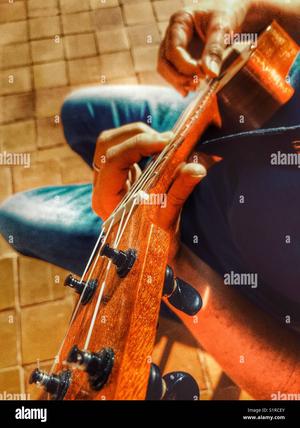 Woman playing a ukulele, high angle side view - Smartphone Captured Stock Image