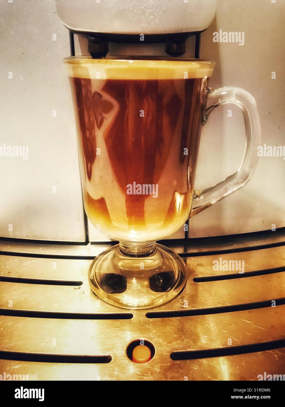 Homemade coffee, using oat milk (which is less dense than coffee and sinks to the bottom of the glass) - Smartphone Captured Stock Image