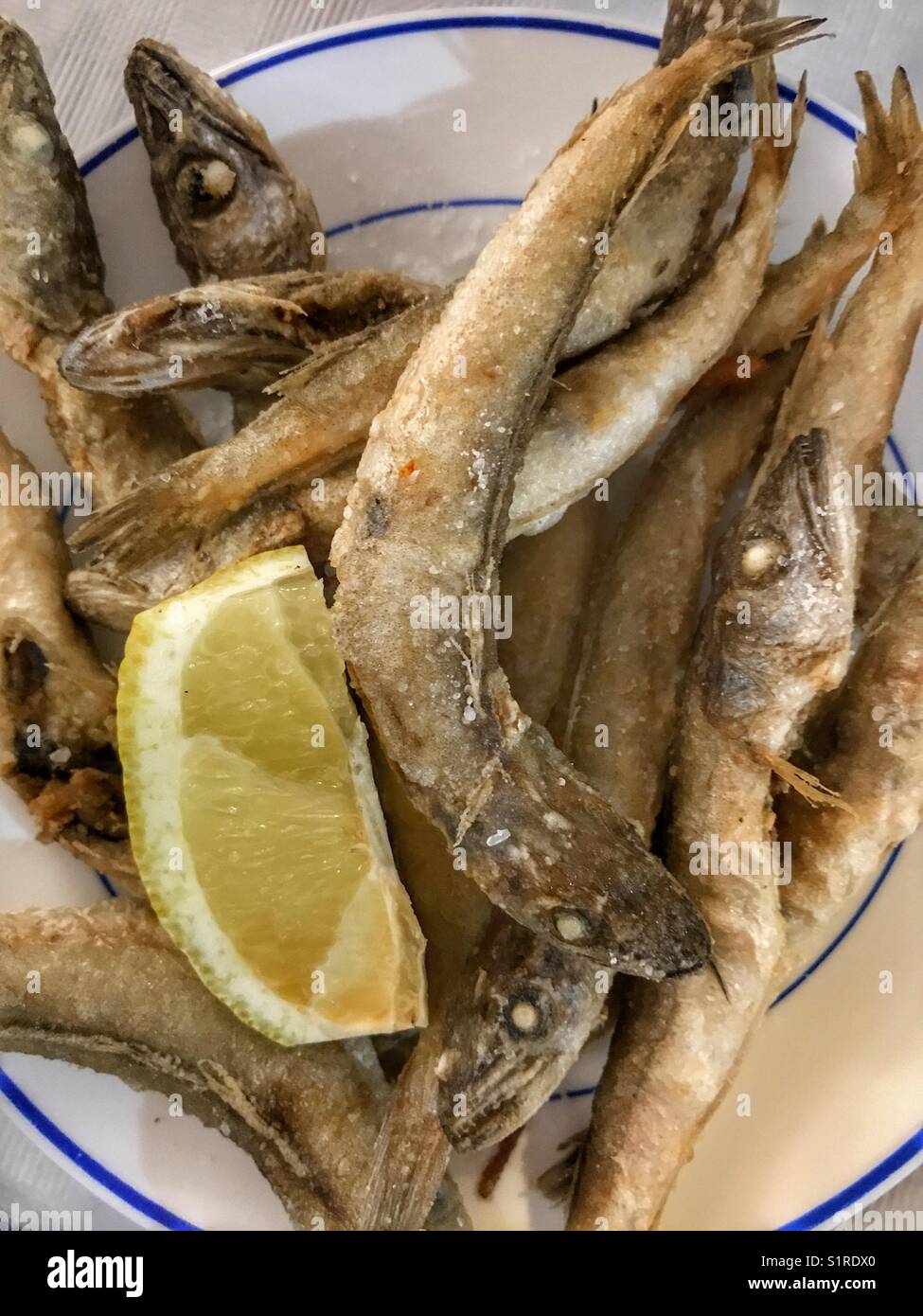 Spanish tapas bar food : deep fried boquerones or bocarones fritos with lemon - Smartphone Captured Stock Image