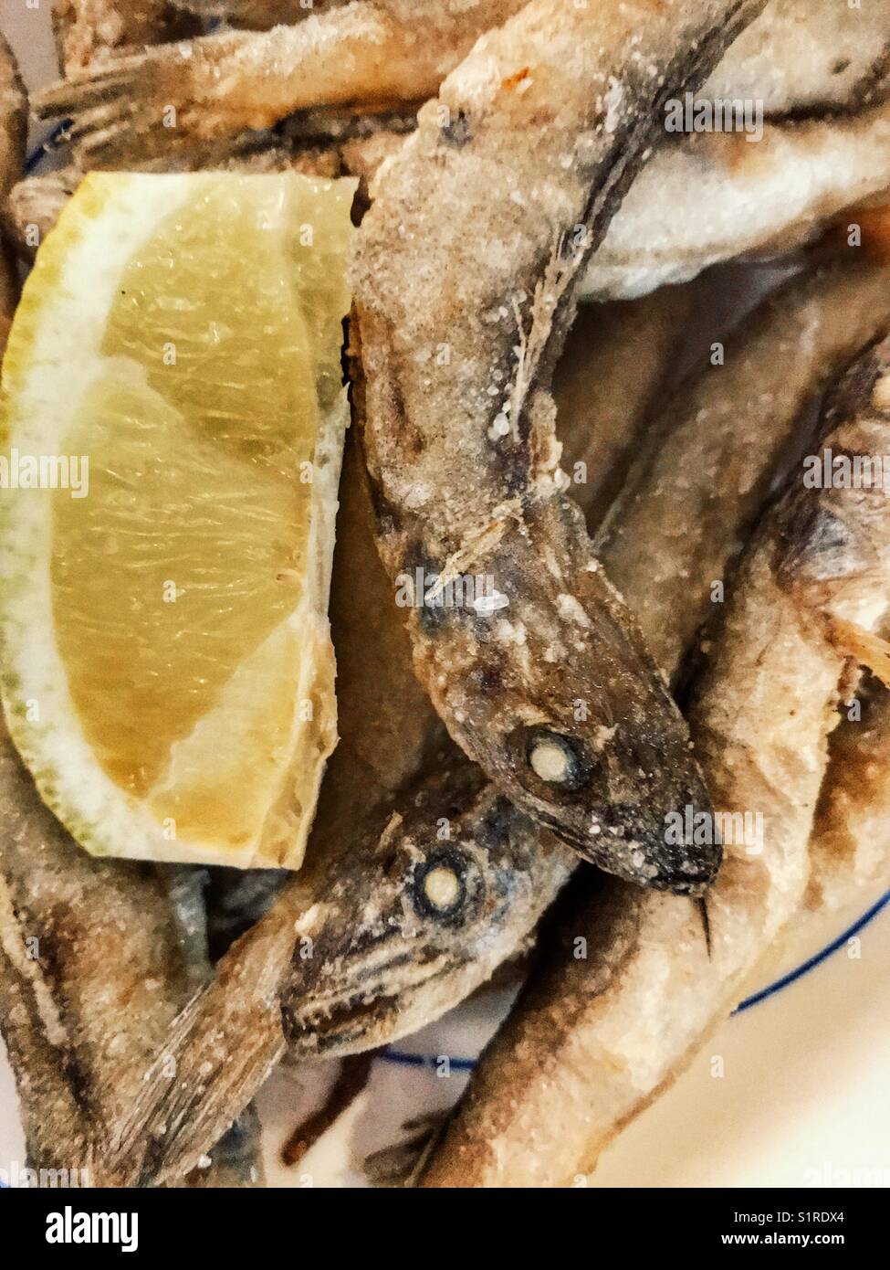 Spanish tapas bar food : deep fried boquerones or bocarones fritos with lemon - Smartphone Captured Stock Image