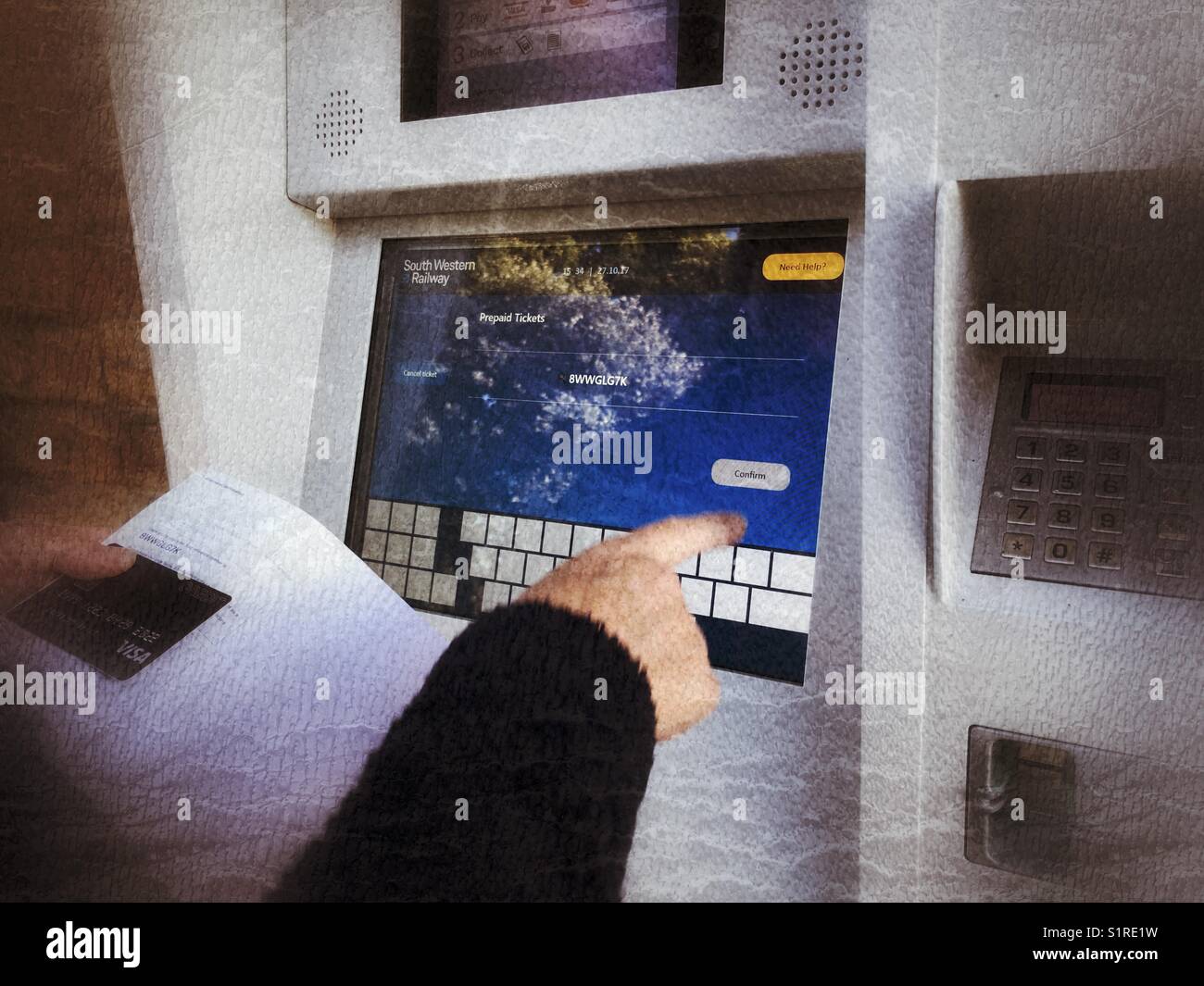 Using a visa credit card to collect prepaid rail tickets from the self service machine at train station - Smartphone Captured Stock Image