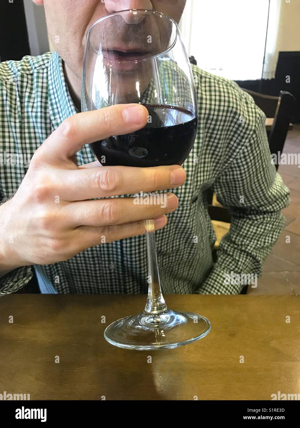 Man drinking a glass of red wine. - Smartphone Captured Stock Image