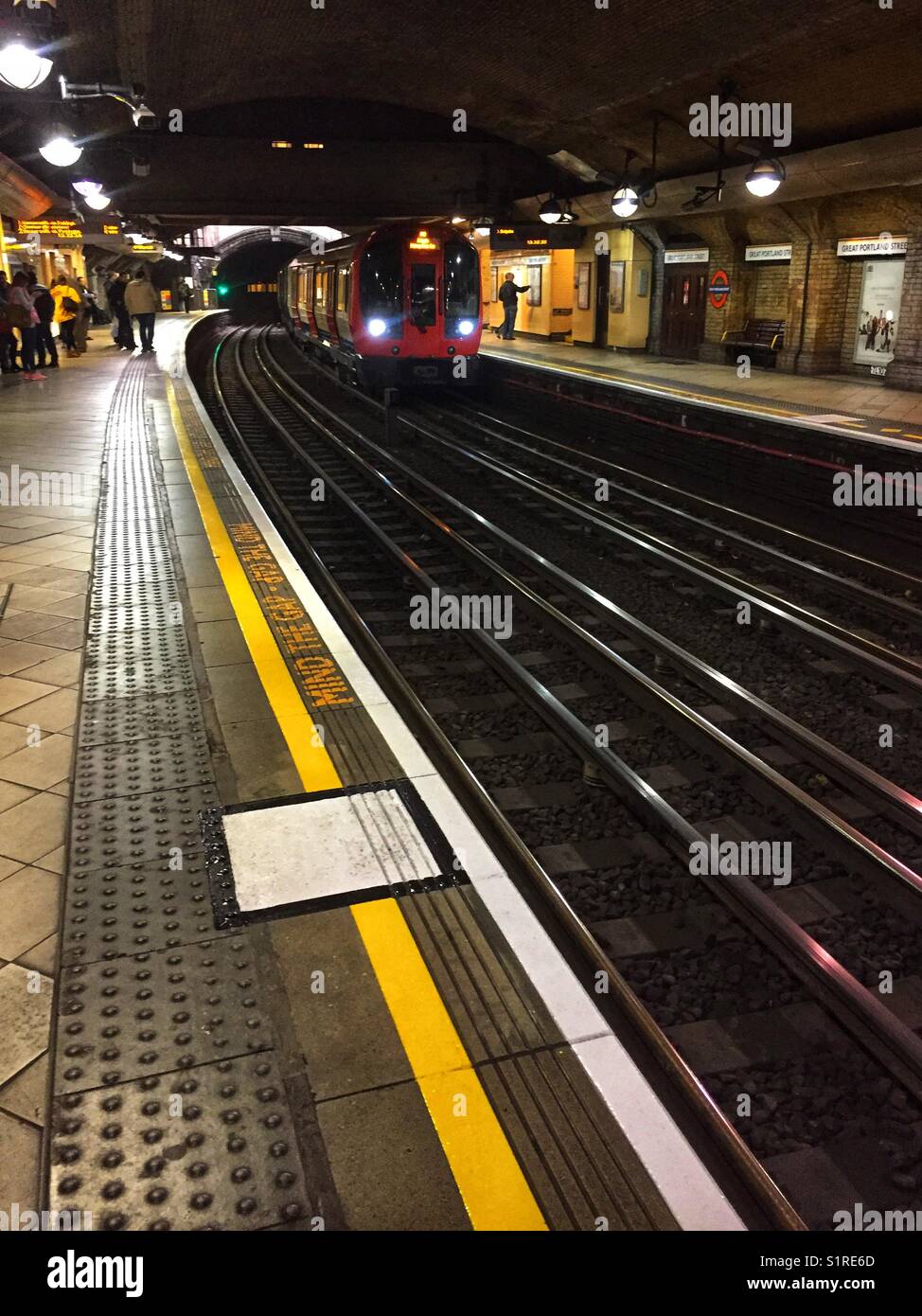 A tube train arrives at Great Portland Street station in London, England - Smartphone Captured Stock Image