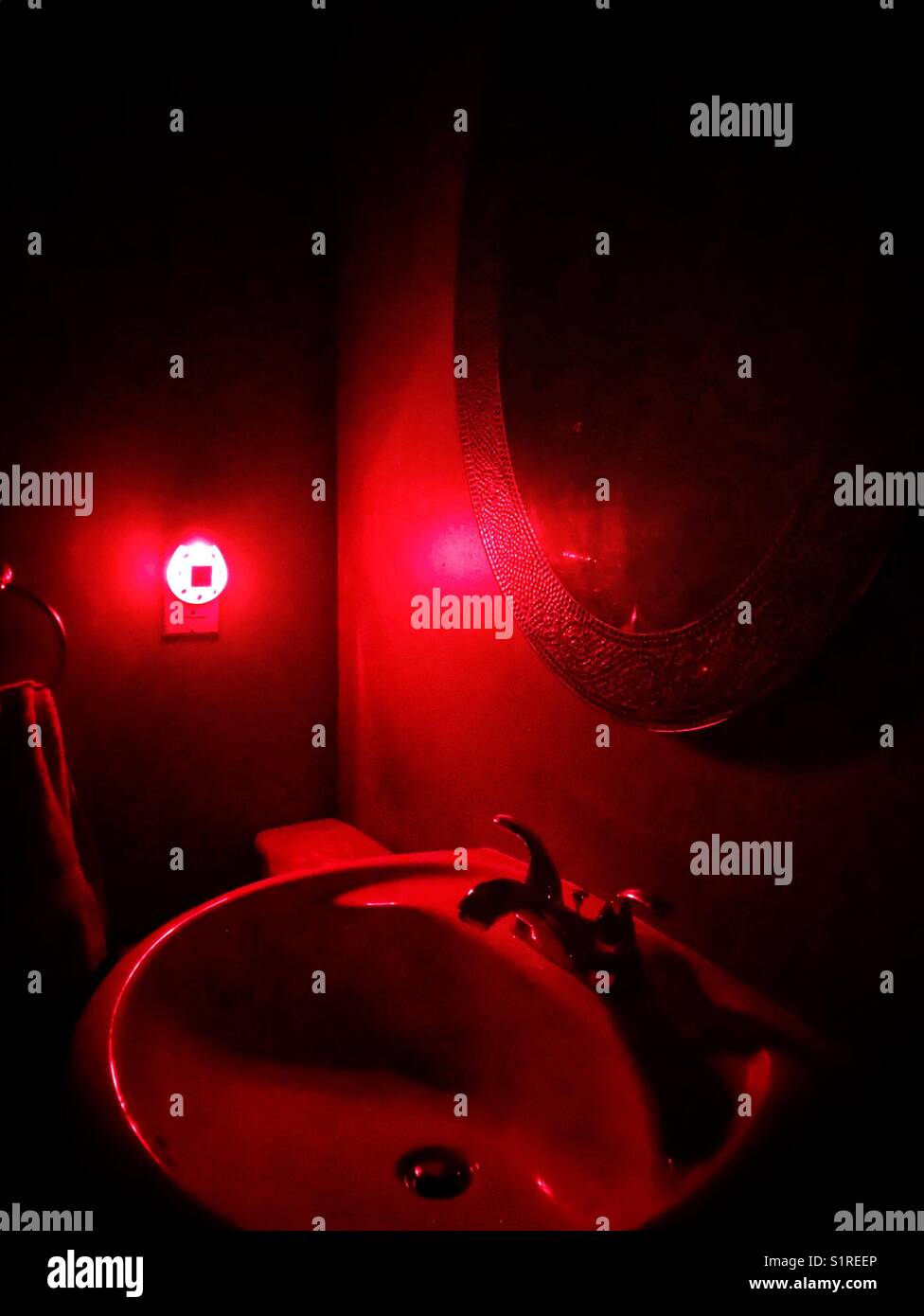 Bathroom sink illuminated by red nightlight Stock Photo Alamy