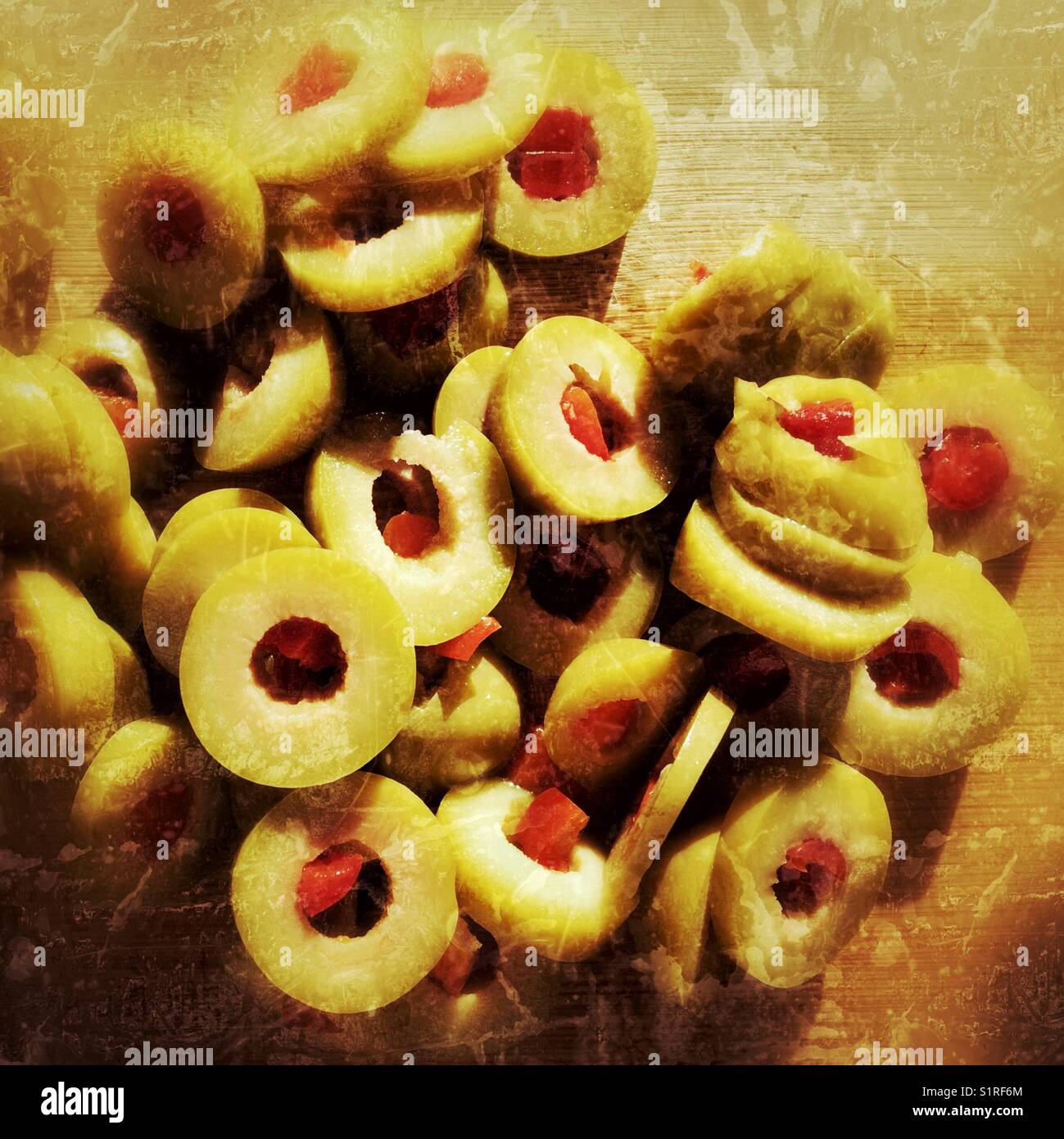Pimento filled olive slices on a wooden cutting board. Natural light. Square crop. - Smartphone Captured Stock Image